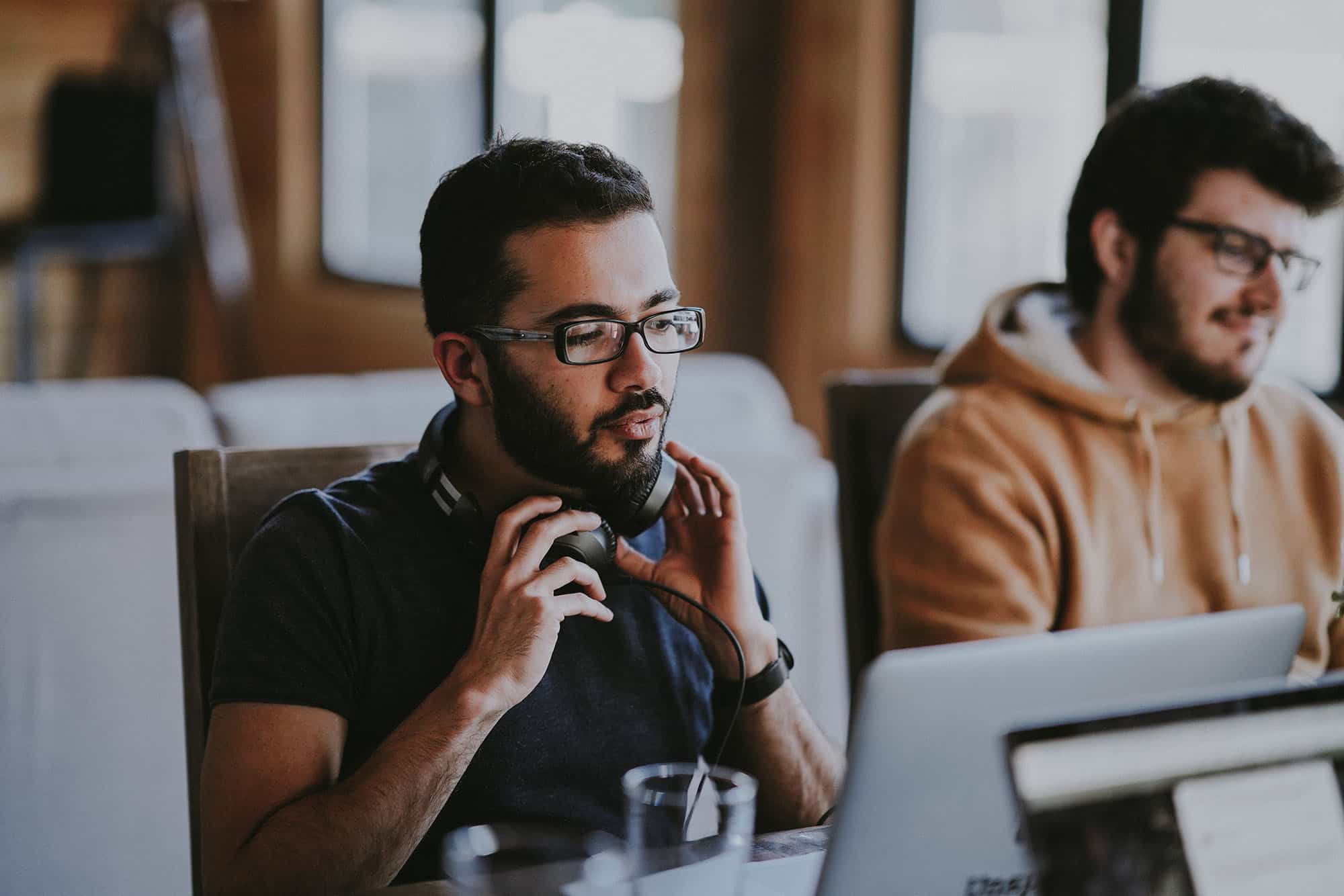 photo of Man using computer and wearing headphones