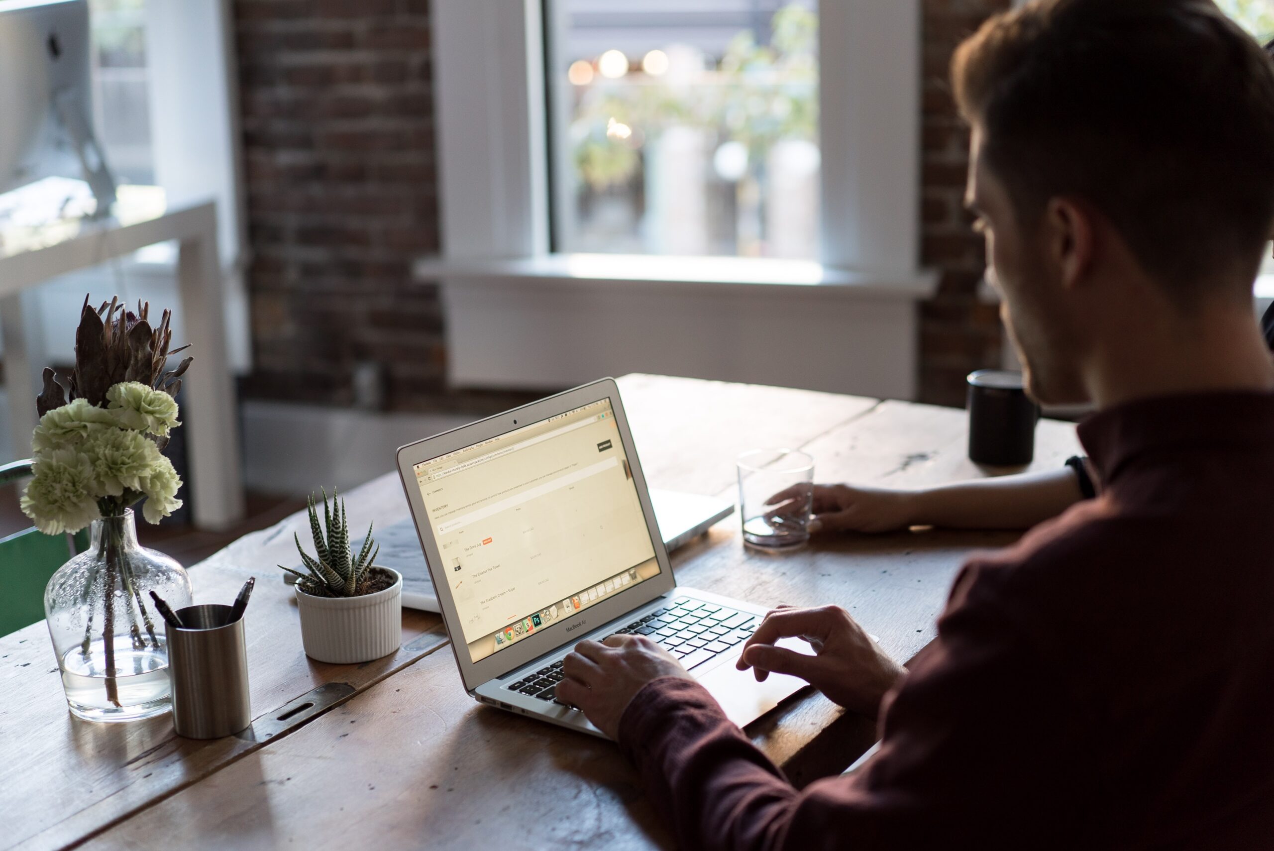 Photo of man working at a laptop, perhaps containerising an app