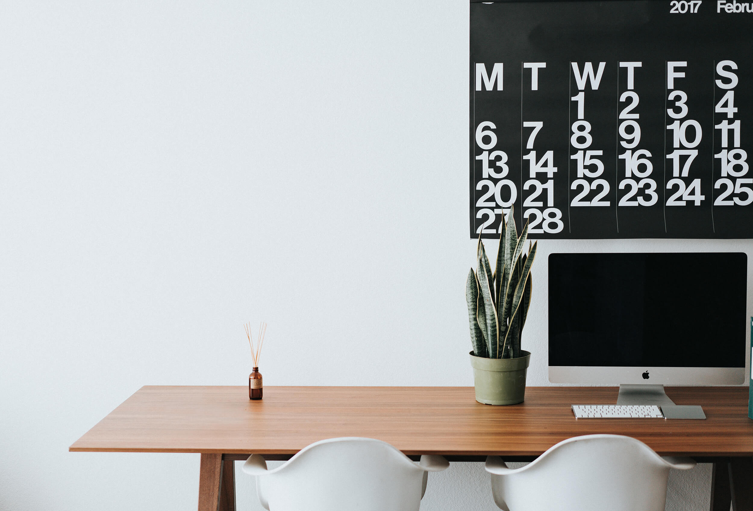 article cover: photo of a calendar and a computer monitor on a wooden desk against a white wall